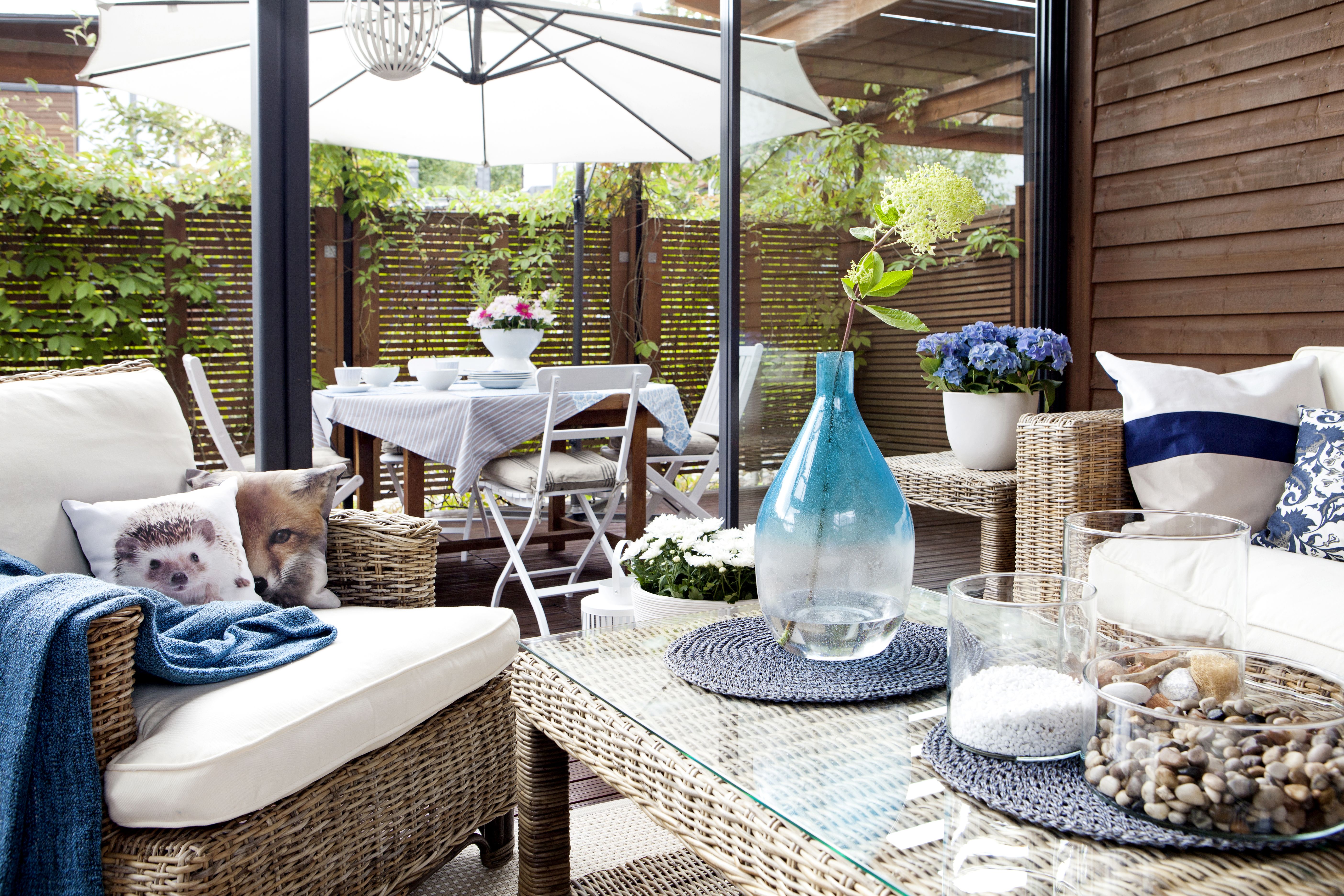 Sinivalkoinen värimaailma on raikas vastakohta punaruskealle laudalle ja vaalelalle rottingille.