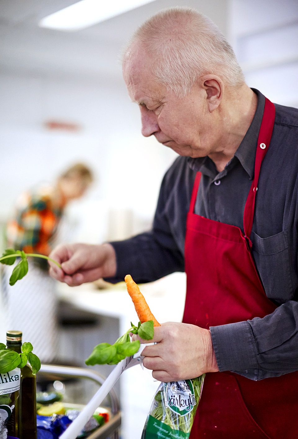 Mikko Mäkinen laittaa basilikaa keiton koristeeksi, porkkanaa mateen kaveriksi.