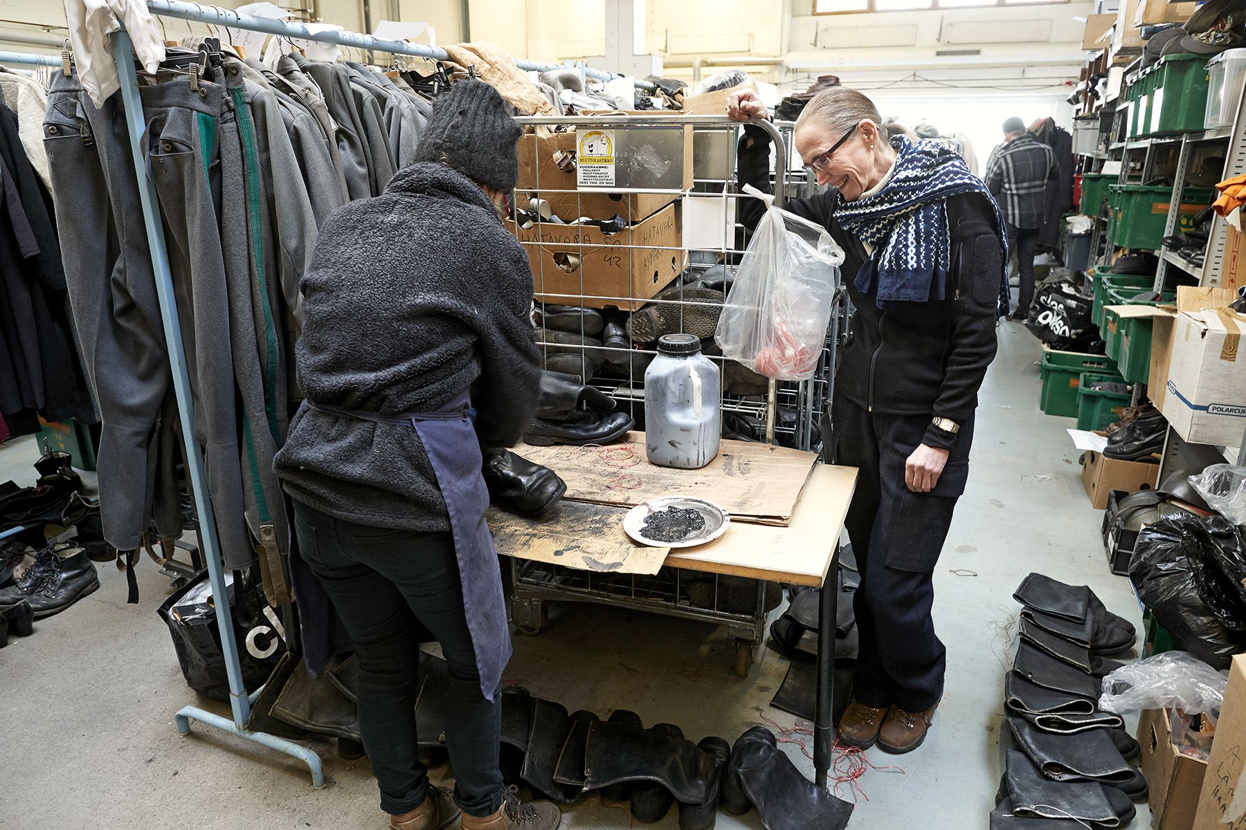 Marjatta Nissinen seuraa, kuinka kenkäsuunnittelija Hanna Kainulainen huoltaa saappaita.