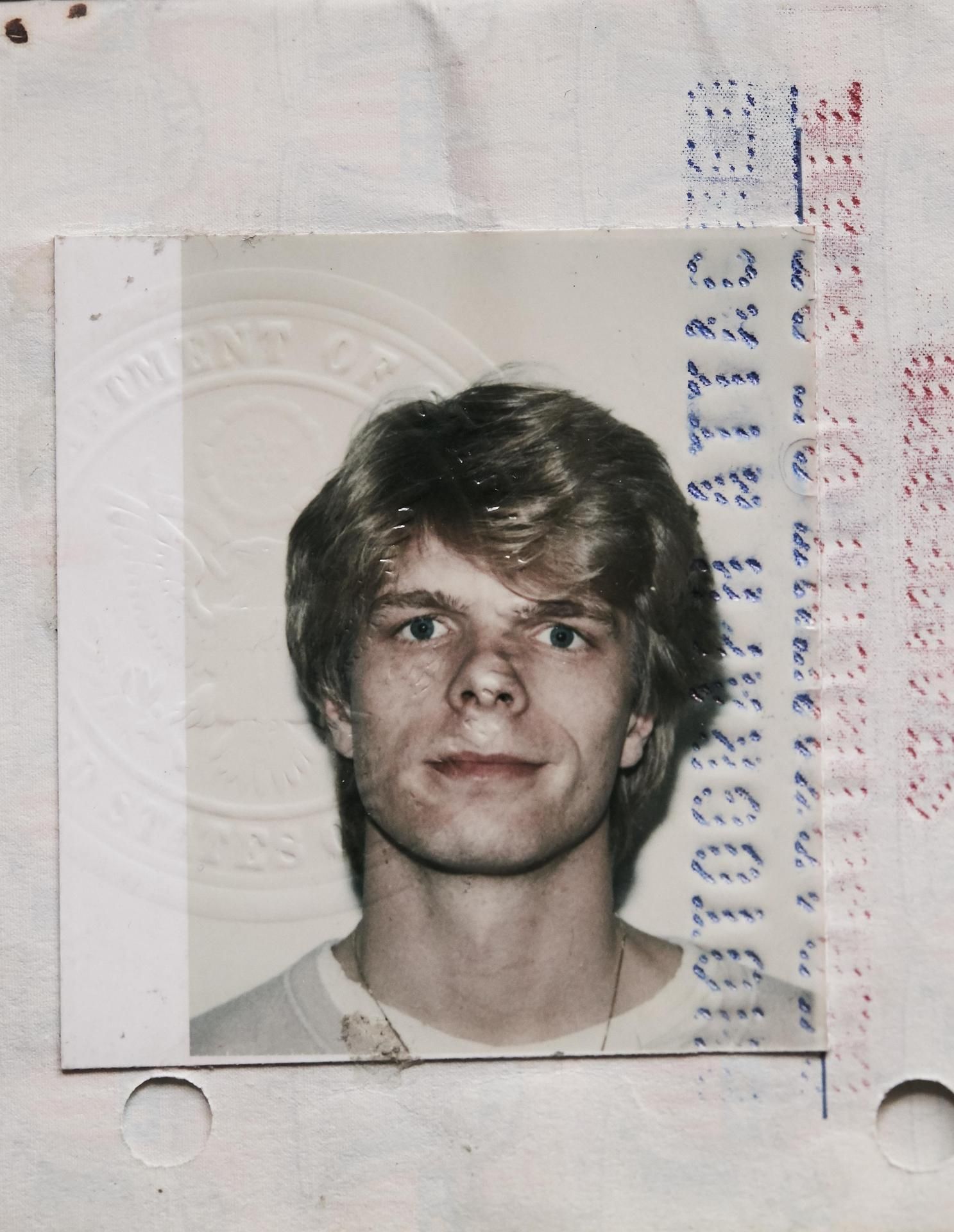 Amerikan-passin kuvasta maailmaa katsoo avoin nuori mies.