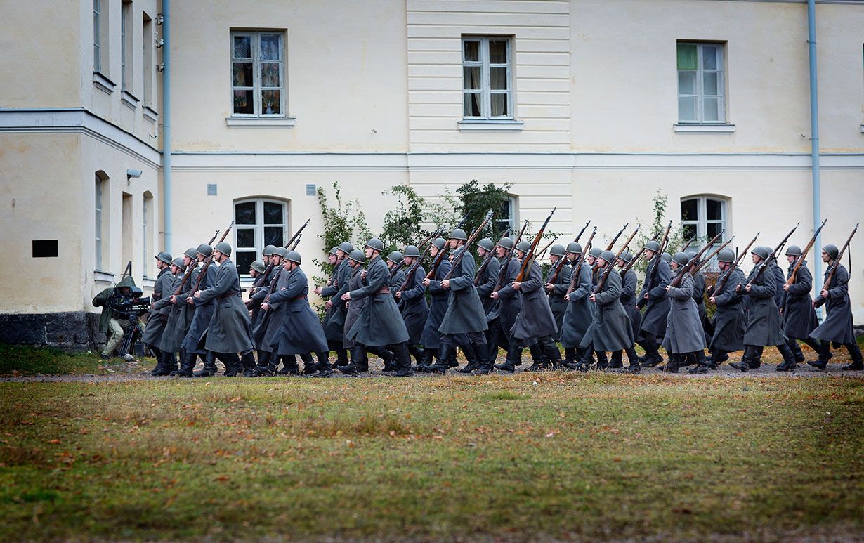 Konekiväärikomppanian miehet marssivat mantteleissaan.