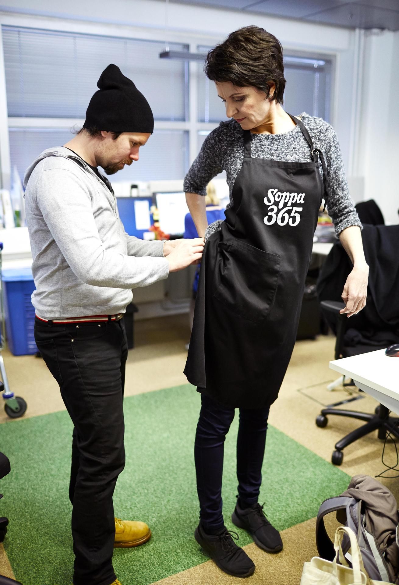 Henry Kahlman kiinnittää mikrofonin Chrissen essuun.