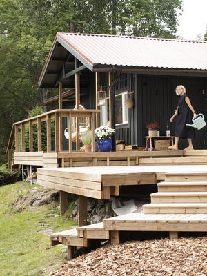  Vaaleanvihreän mökin uudeksi väriksi Sissu valitsi tumman männynlatvan vihreän. Terassin hän pitää kunnossa ruskealla puuöljyllä.