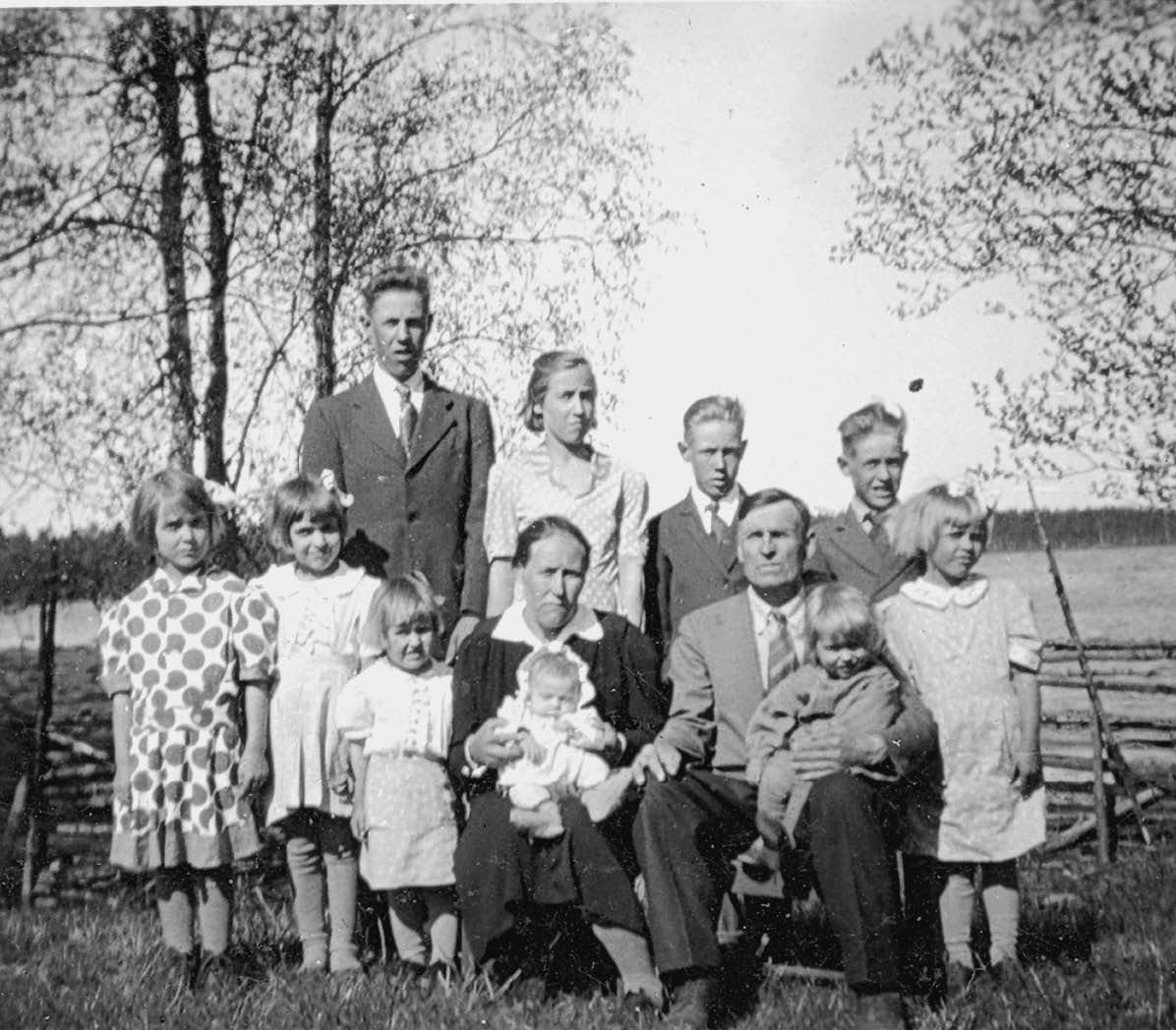 Koko perhe kesällä 1948. Takarivissä Heimo (vas.), Raili, Jussi ja Taito. Eturivissä Milja, Pirkko, Raija, Fanni-täti sylissään Aaro-kuopus, isä Aleksi Eeron kanssa ja reunimmaisena Kaino-sisko.