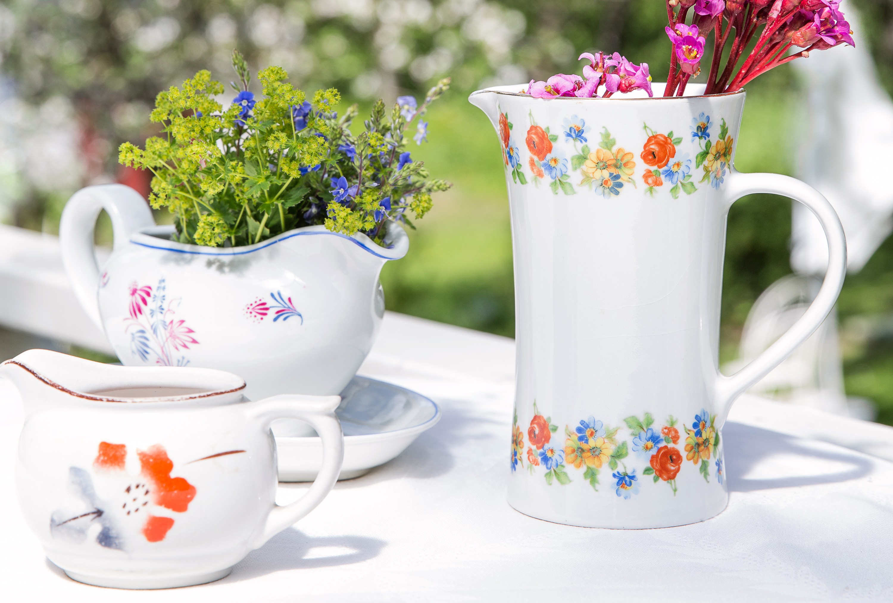 Pikkukannu edessä on Greta Liisa Jäderholm-Snellmanin puhalluskoristeinen ML-malli, 25 e. Korkeassa kannussa on siirtokuvakoristelu, 35 e. Takana Olda Osolin ja Reinhard Richterin suunnittelema kastikekaadin 40-luvulta, 54 e.