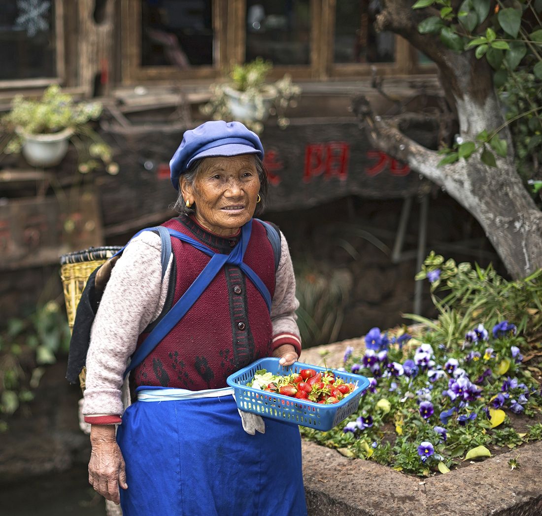 Naxi-heimoon kuuluva rouva myy kulkijoille välipalaa.