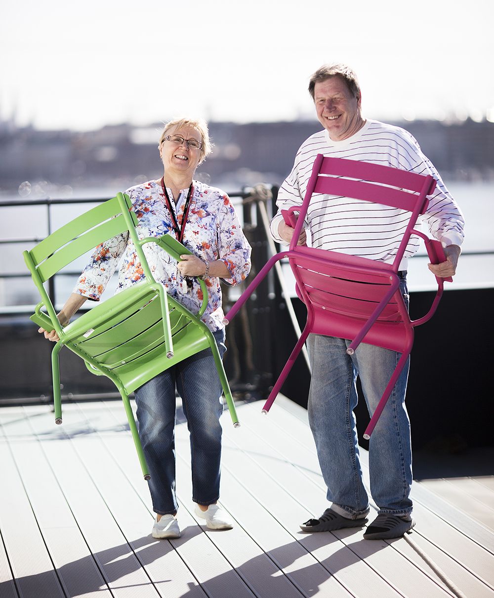 Leena Vahtera ja Jorma Kaunismäki asettelevat tuoleja avaralla kattoterassilla.