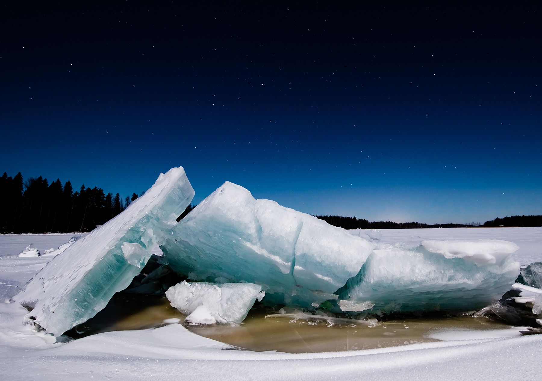 Kuvaaja Tapio Niemi. ”Lappajärven Kärnänsaaren edustalla oli pakkasta 26 astetta. Vedin pilkkihaalarit jalkaan ja tallustelin jäätä pitkin kilometrin, jotta löysin parhaan kuvauspaikan. Mukana oli jalusta ja kamera. Hanki narisi jalkojeni alla, täysikuu paistoi ja valaisi tienoon komeasti.”