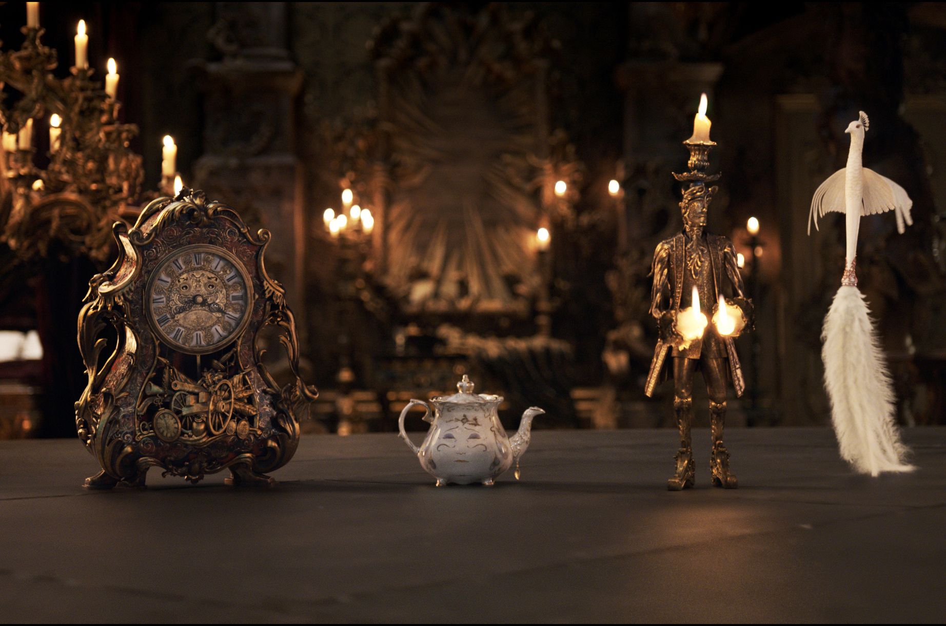 Linnan irtamisto on elossa. Könni-kello (Ian McKellen), Rouva Pannu (Emma Thompson), Lumiére-kynttilänjalka (Ewan McGregor) sekä Plumette-pölyhuiska (Gugu Mbatha-Raw). 