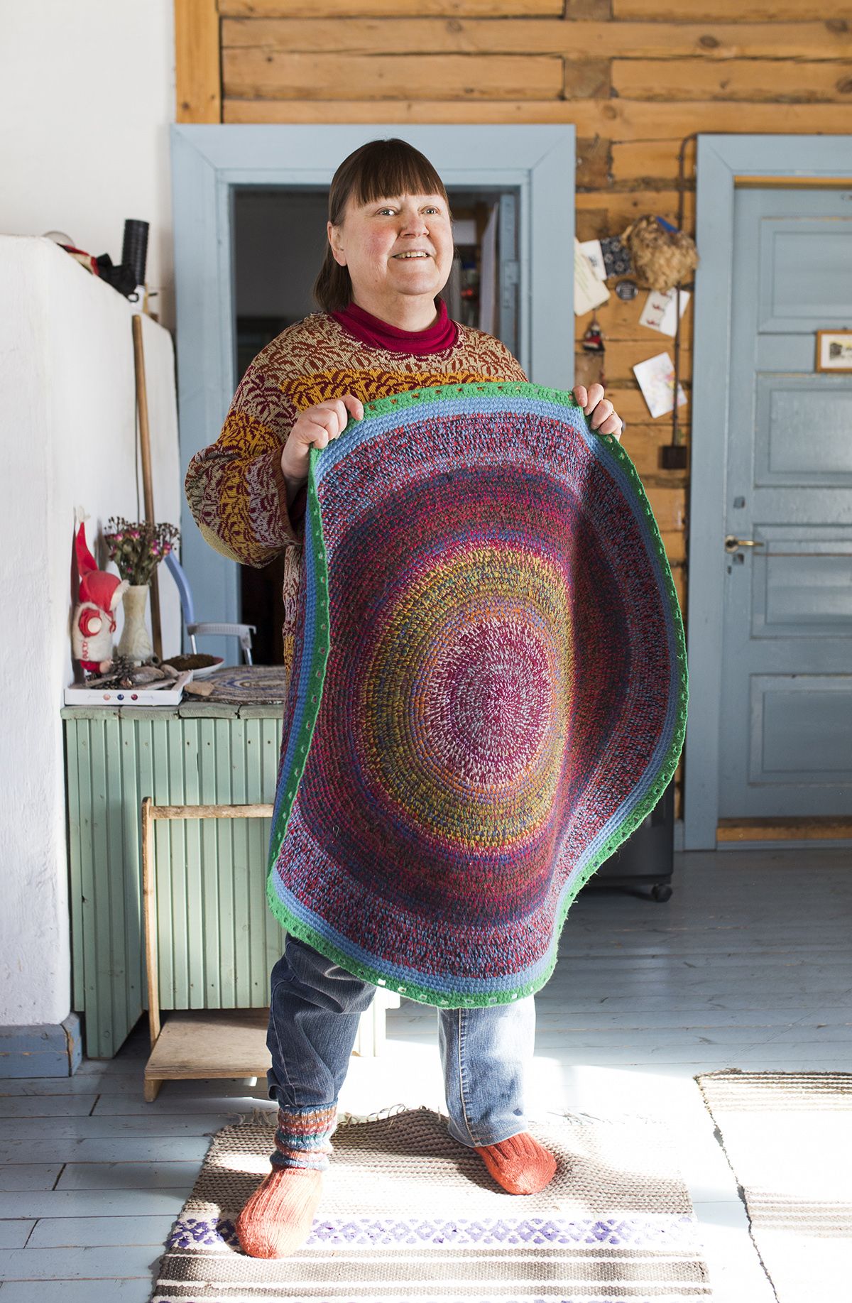 Värit ovat Nyyskälle tärkeitä. Hän näkee ihmisetkin väreinä. Matto on vuokkiniemeläisen ystävän Roza Rdmsujevan tekemä.