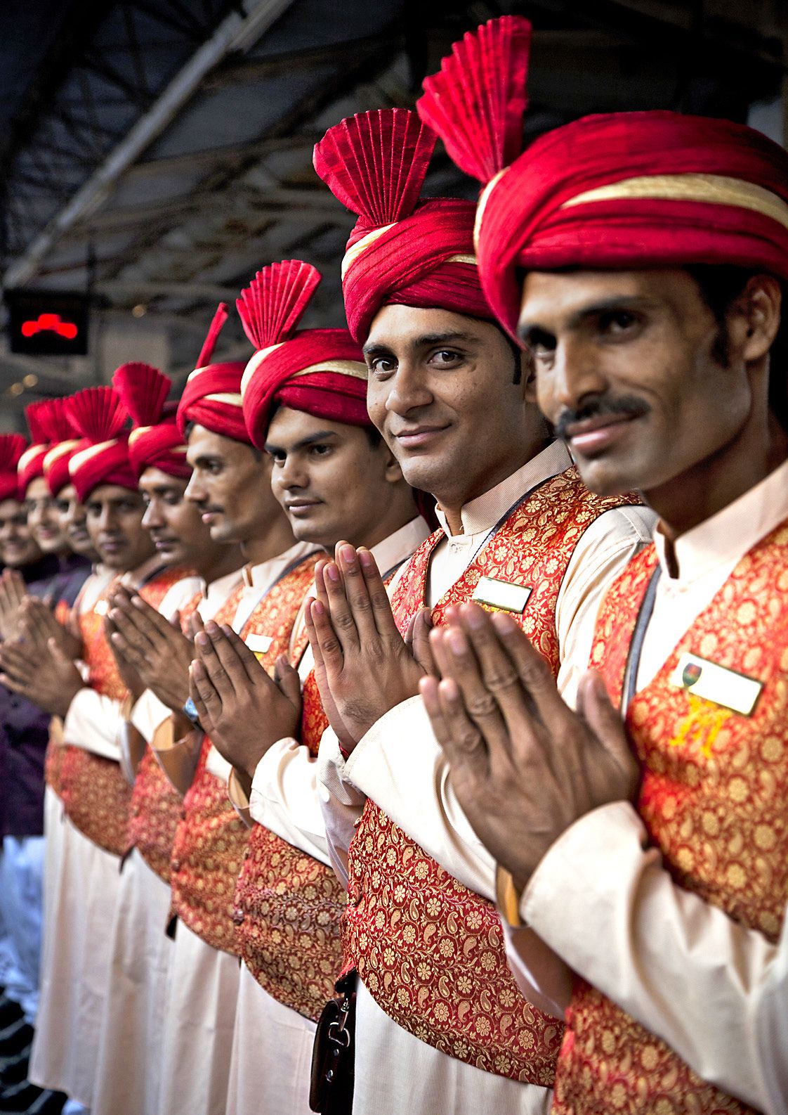 Henkilökunta ottaa matkailijat vastaan rivissä kädet intialaisessa tervehdysasennossa.