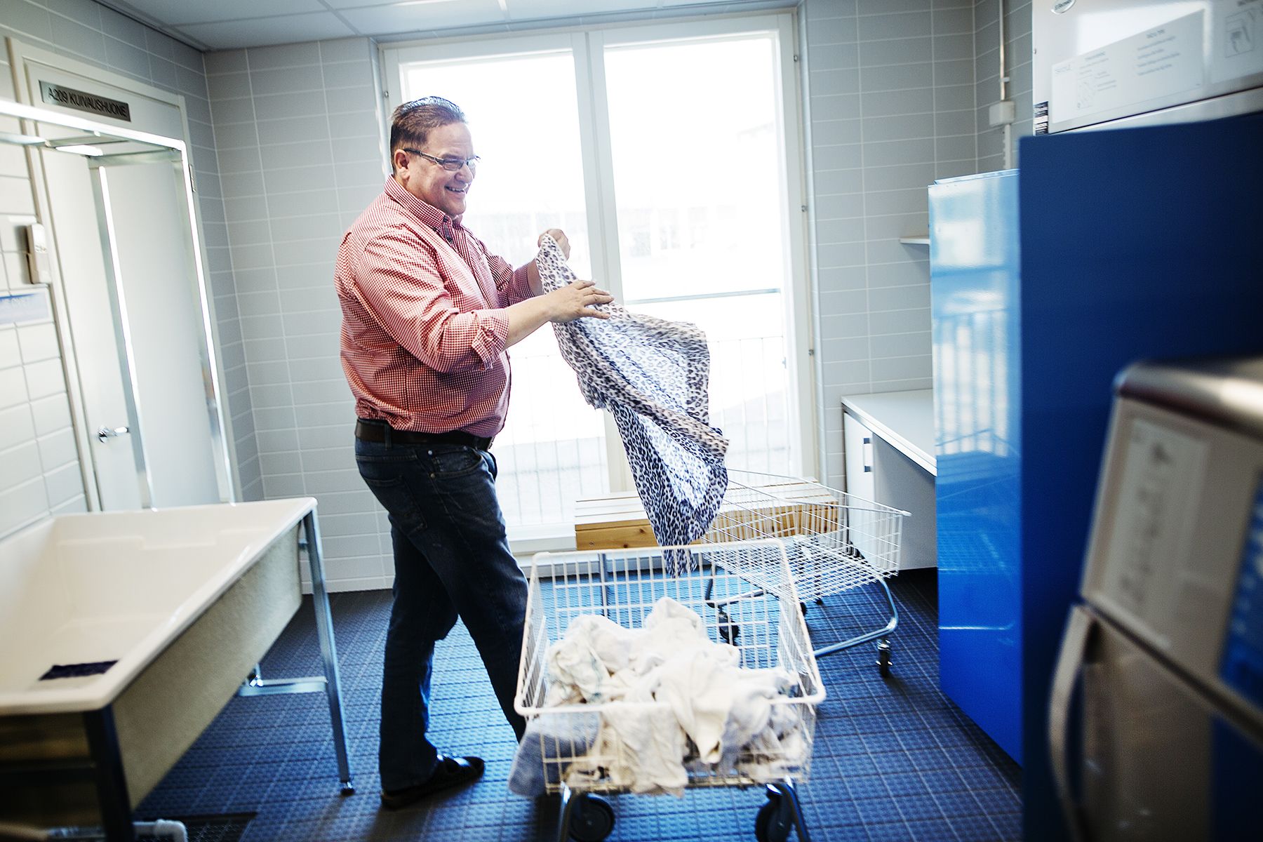 Jyrki Tiainen kehuu pyykkituvan koneita tehokkaiksi.