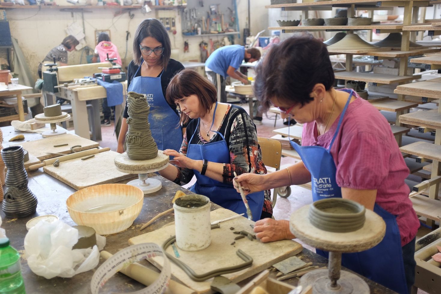 Marjatta (oikealla) ja Ritva keskittyvät työhön. Giuseppe Liberatin tytär Marta neuvoo.