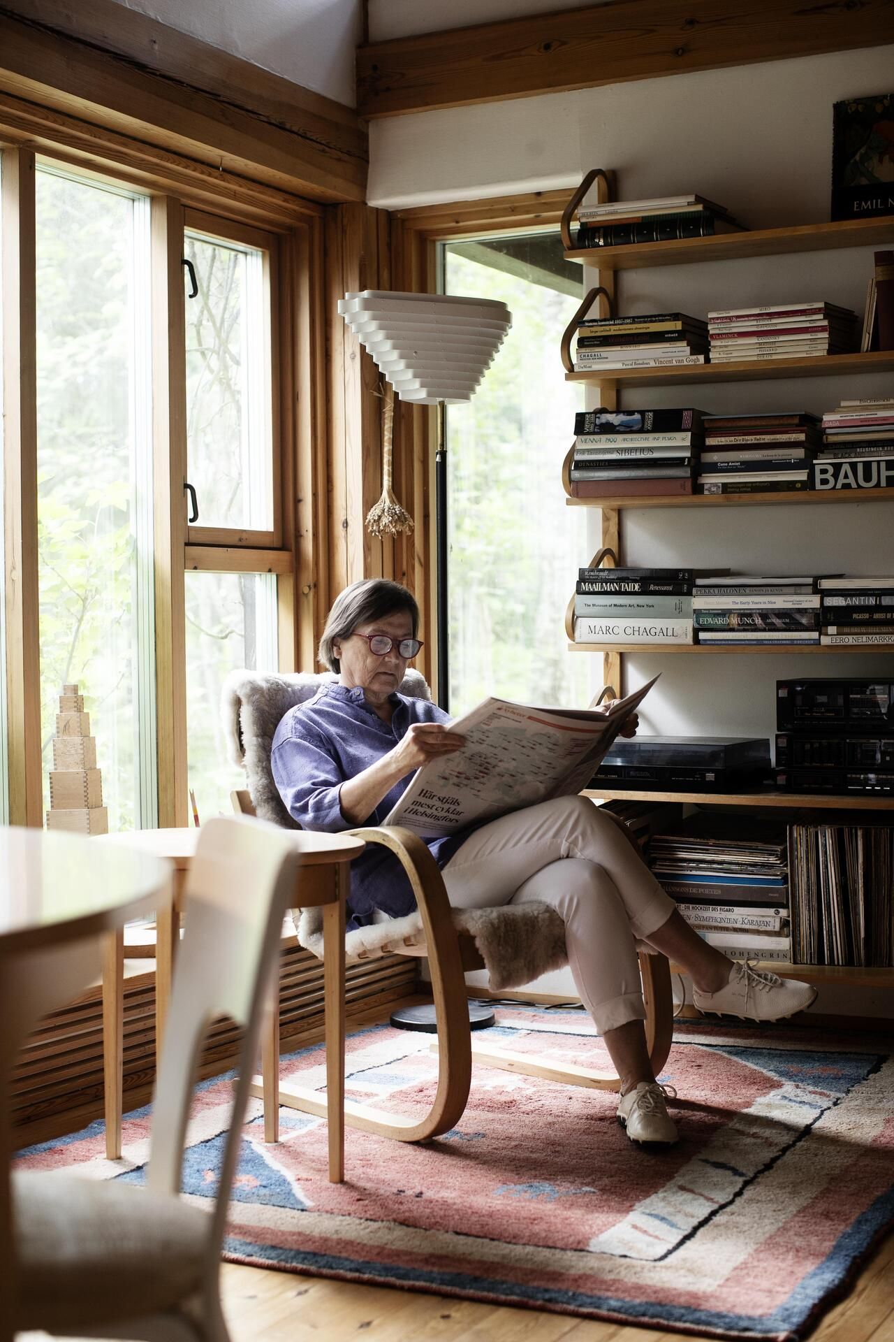 Eva istuu luolan suulla eli olohuoneen valoisassa päädyssä.