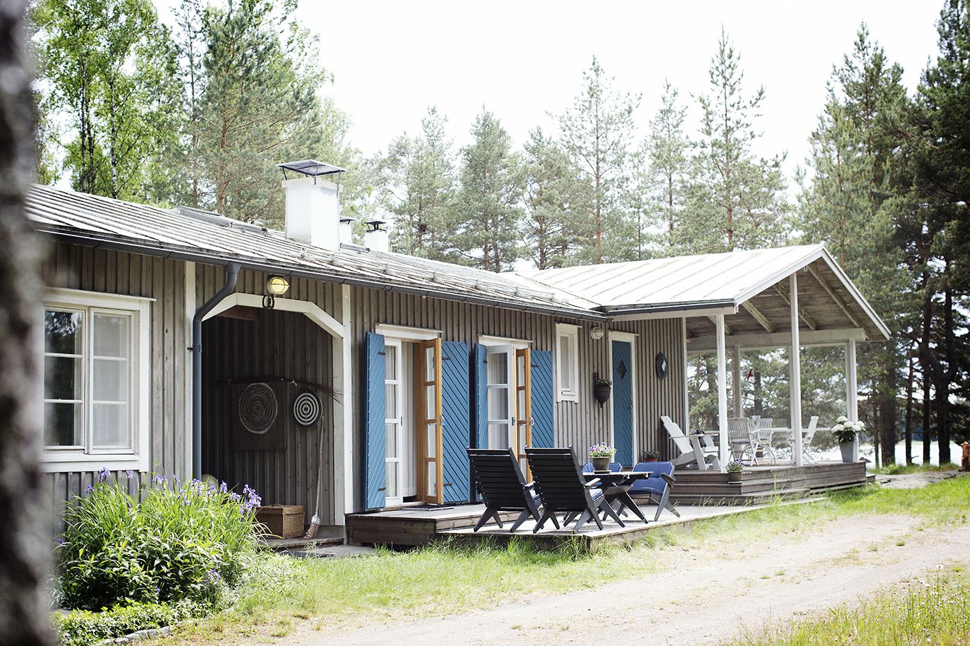 Mökin harmaa väri löytyi lukuisten kokeilujen kautta. Siniset aitanovet antavat väriä julkisivuun.