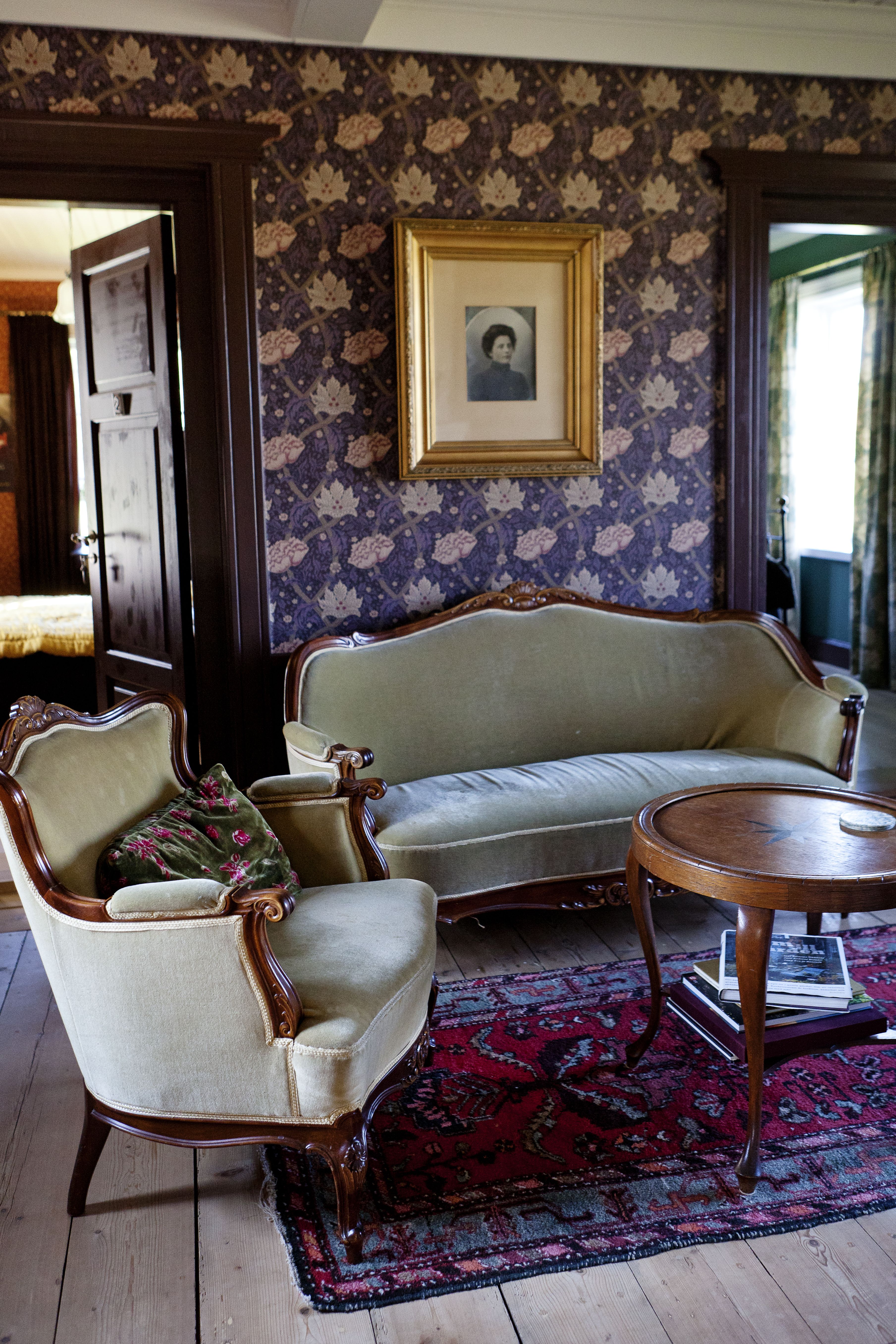Sali on tapetoitu William Morrisin tyyliin. Emma-tädin kuva on kehystetty seinälle.