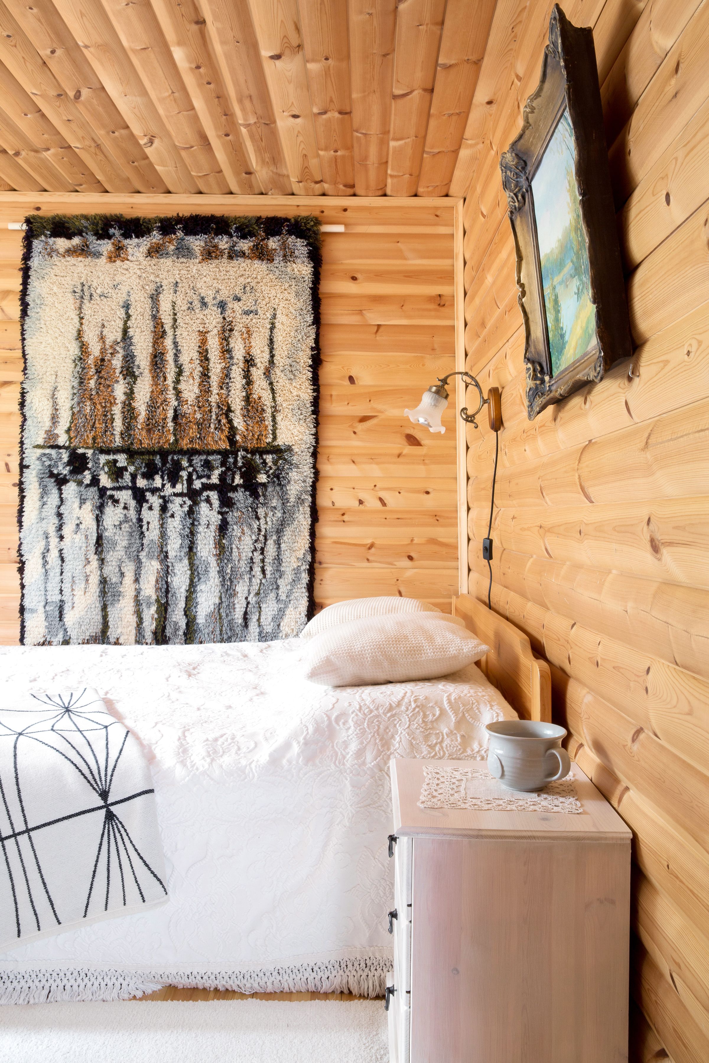 Makuuhuone on mökin valoisin. Tämäkin hieno ryijy löytyi kirpparilta. 